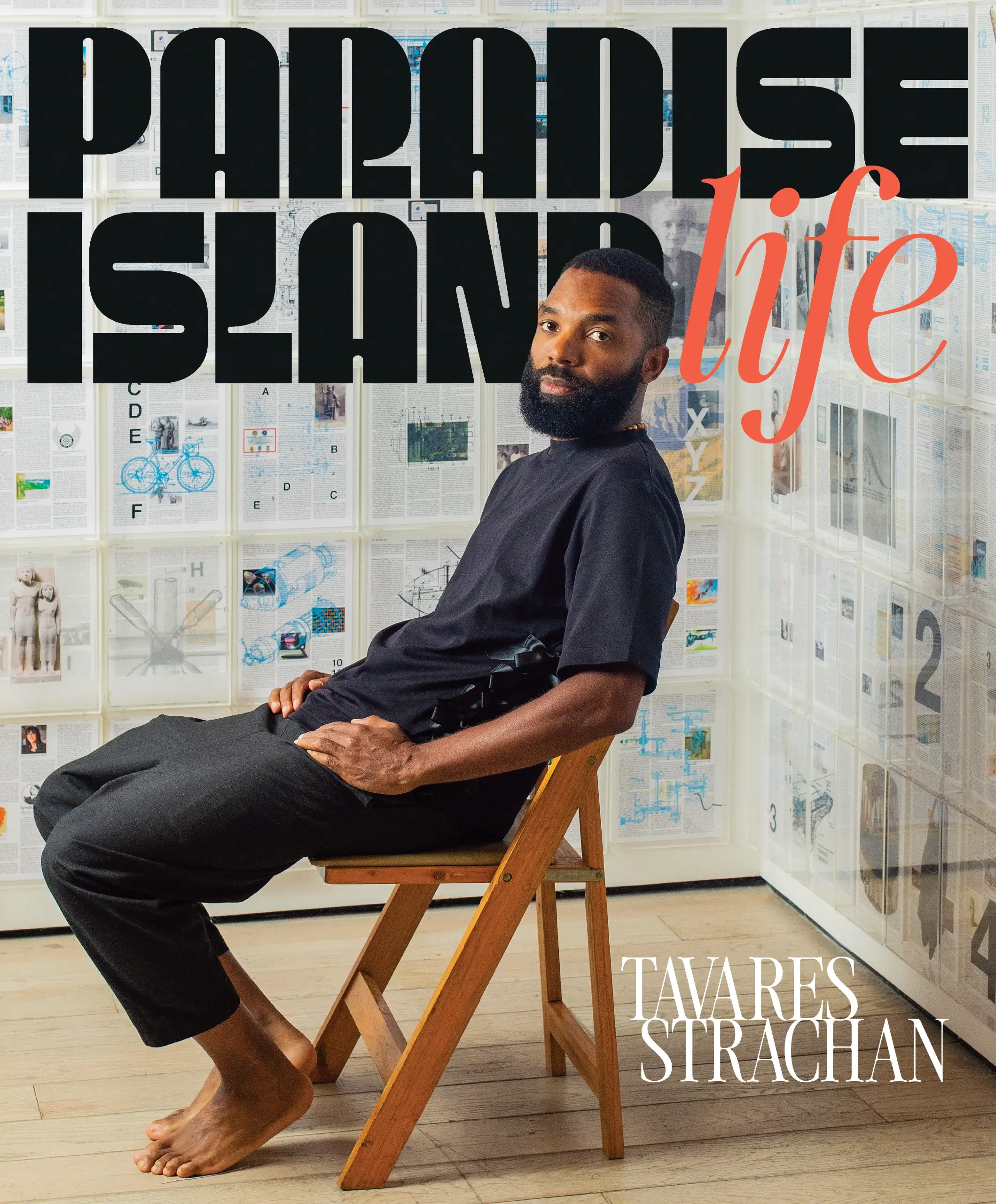Tavares on the cover of paradise island life issue 02 sitting on a wooden chair surrounded by his work.